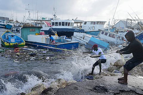 Fishermen pull a damaged boat